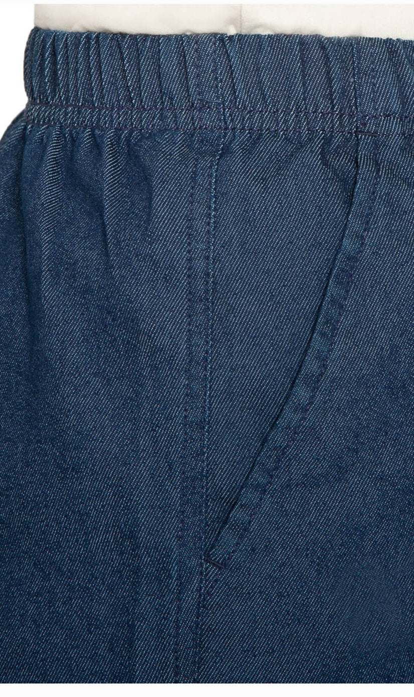 Close-up of blue denim shorts with a white background